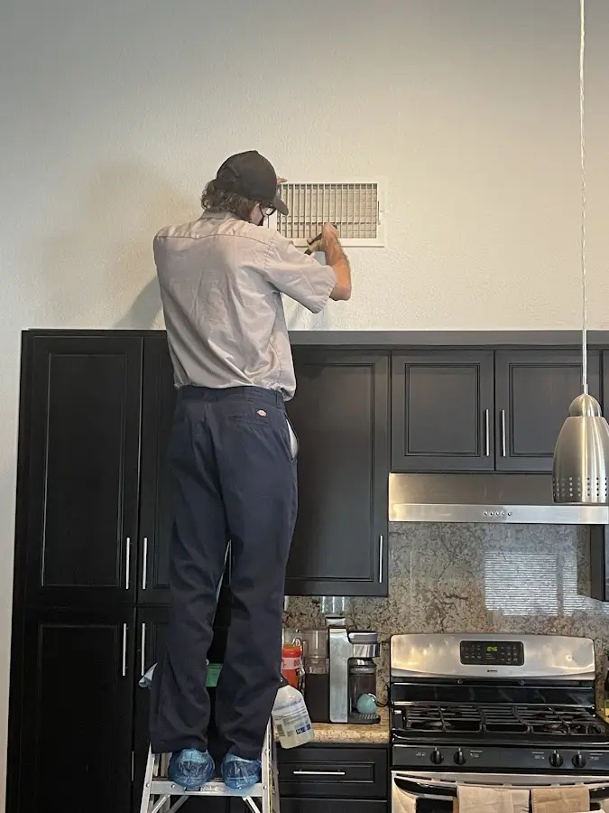 Technician inspecting an air vent during HVAC service in Chillicothe